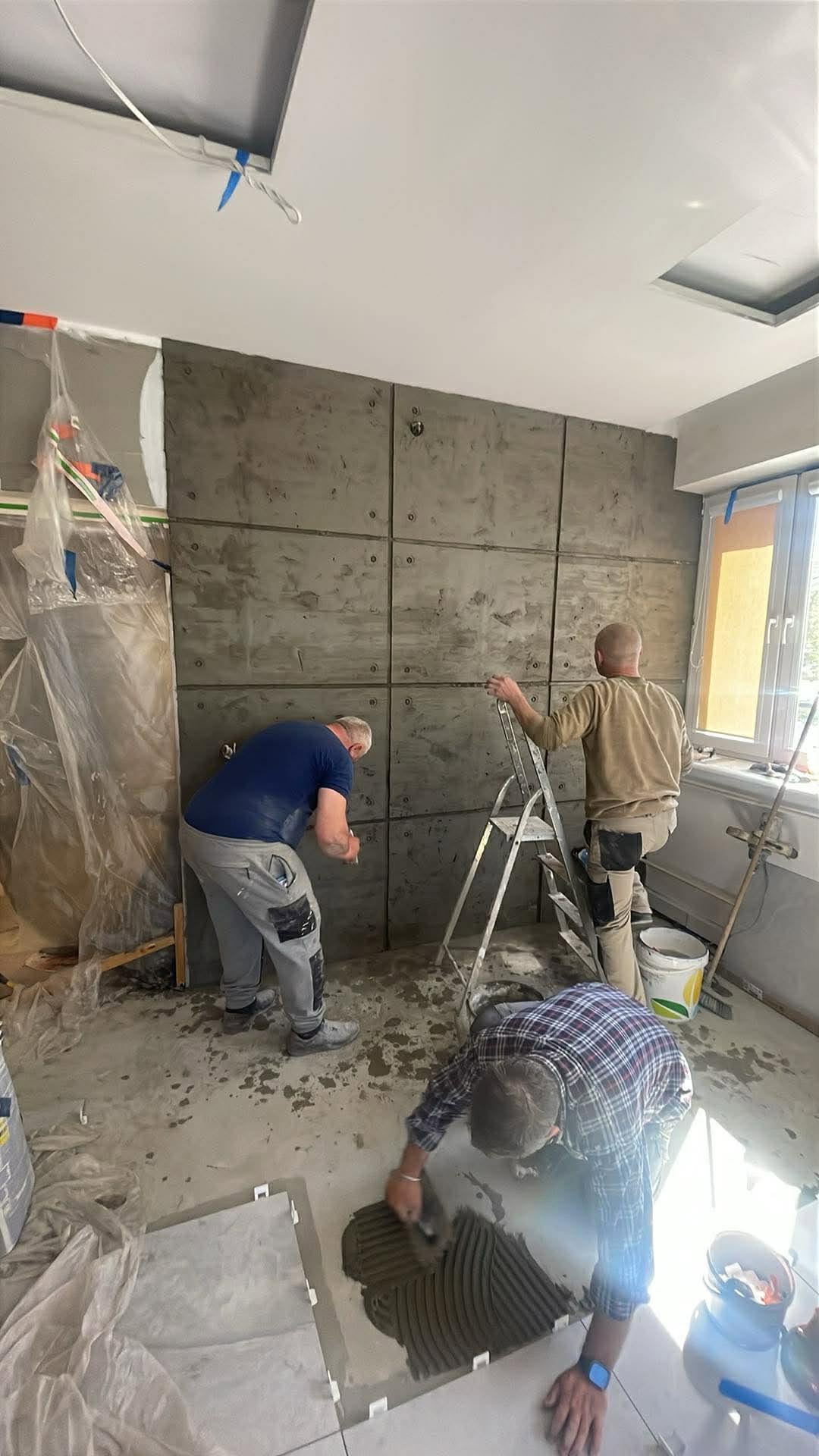 Wykańczanie wnętrza: ściana w stylu betonu architektonicznego i układanie płytek podłogowych